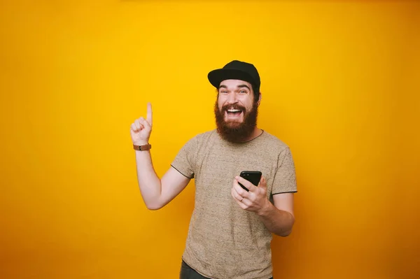 Retrato Hombre Alegre Con Barba Sosteniendo Teléfono Apuntando Hacia Fondo — Foto de Stock