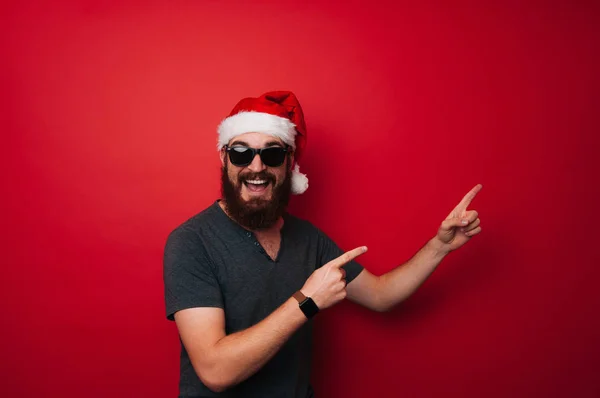 Portrait Cheerful Man Beard Wearing Santa Claus Hat Pointing Away — Stock Photo, Image