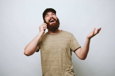 Arkadaşıyla telefonda konuşurken mutlu sakallı adam fotoğrafı