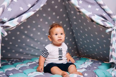 Çadırda oturan üzgün şirin bebek