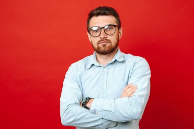Sakallı adam ciddi seyir ile çapraz eller