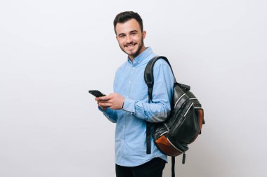 Genç adam manifatura gülümseyen ve bir sırt çantası takmış portre