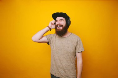 Adam listeningfavorite müzik kulaklık üzerinde mutlu gülümseyerek portresi sakallı