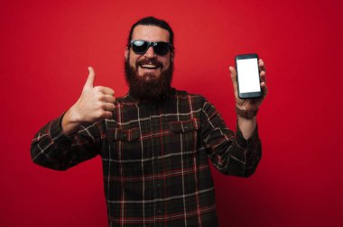 Onun nea mobille mutlu ve el başparmak ile sakallı hippi erkek gömlek