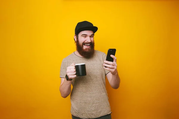 Feliz Joven Sonriente Está Enviando Mensajes Móvil Sosteniendo Una Taza —  Fotos de Stock