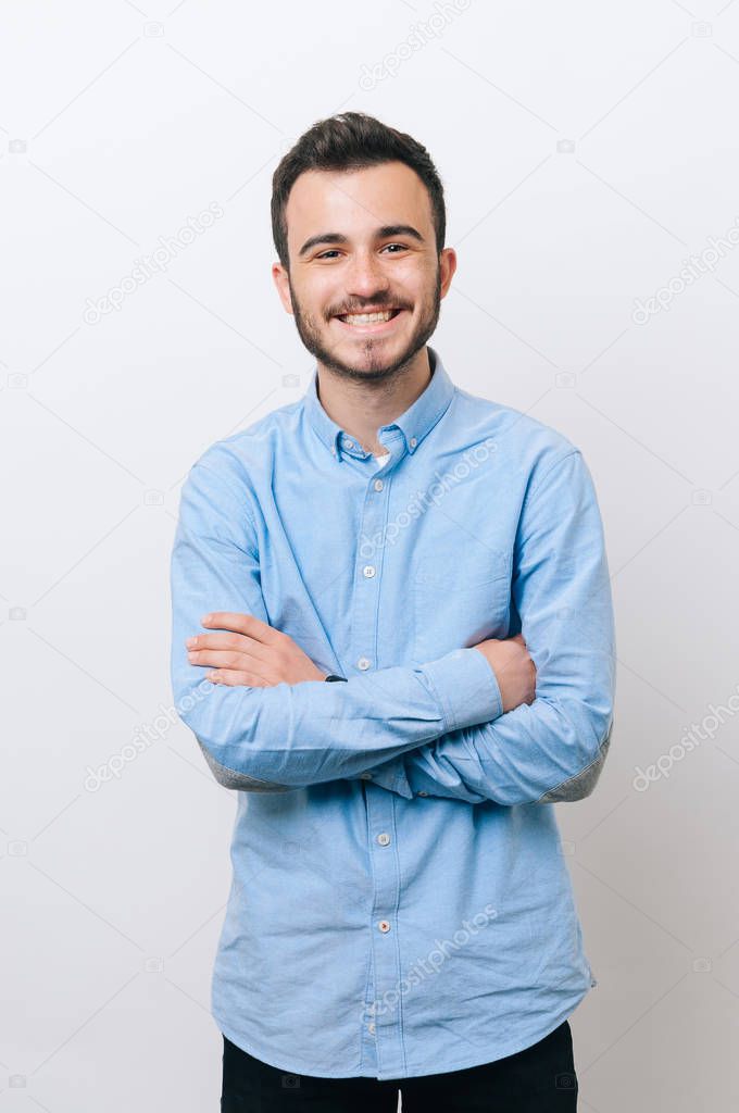 Portrait of happy young man with crossed hands 