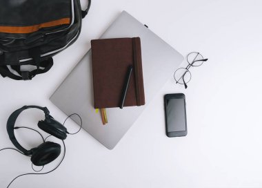 Düz lay yakışıklı personel, headphiones, gözlük, laptop, dizüstü, beyaz arka plan üzerinde mobil ile 