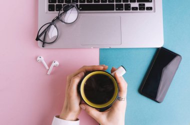 PIN mavi çalışma alanı tablosu laptop, gözlük ve smartphone ile en iyi kadın el Kupası kahve, düz ile tutarak görünümünü yatıyordu