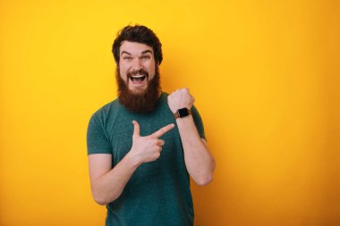 Yakışıklı adam acele saat, Sabırsızlık, izlemek için işaret rahat t-shirt giyen süre gecikme için üzgün 