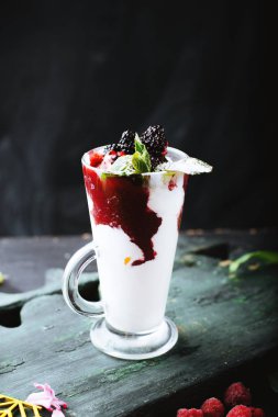 Meyve ve çilek ahşap düz ve koyu arka plan üzerinde taze soğuk yüzlü bardak 