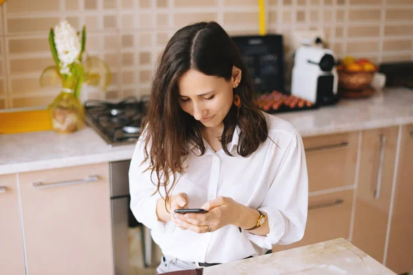 Mujer Joven Usando Teléfono Inteligente Mesa Cocina Hogar Moderno Morena — Foto de Stock
