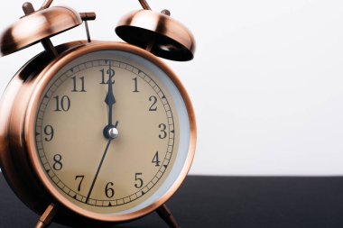 Siyah tablo ve beyaz duvar arka plan üzerinde Vintage bronz saat alarm 