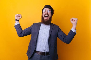 Zafer! Genç adam resmi içinde seyir iyi rised silahlarla mimik ve karşı çığlık ayakta gülümseyen sarı arka plan