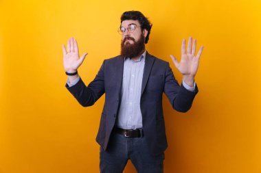 Do not look at me, it was not my fault. Portrait of unaware worried bearded guy in formal  raising palms in surrender gesture clipart