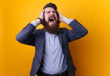 Sakallı zarif adam takımlı ellerle kamera sarı arka planda çığlık kafa sıkma.