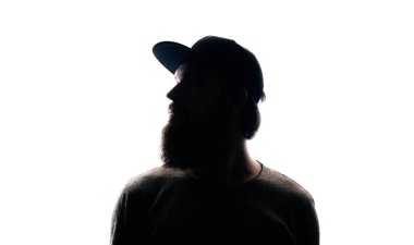 Sakallı adam portre siluet arka ışık içinde. Mna uzakta beyaz arka plan üzerinde seyir yakışıklı sakallı