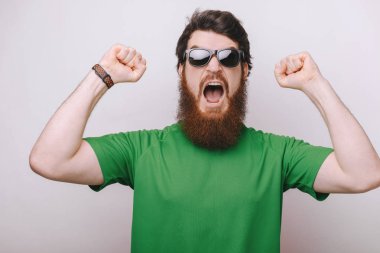 Büyük iş! Çok heyecanlı genç brunet sakallı adam kutluyor. O el zaferdir 