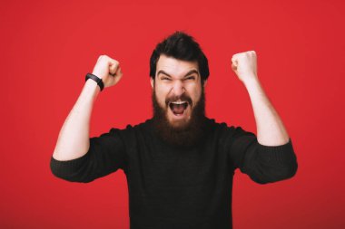 Şanslı genç hipster adam. Kazanan! Genç sakallı brunet bir rüya. Çok heyecanlı,
