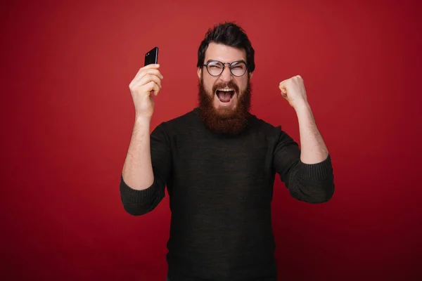 Retrato Joven Barbudo Sonriente Con Gafas Pie Aislado Sobre Rojo —  Fotos de Stock