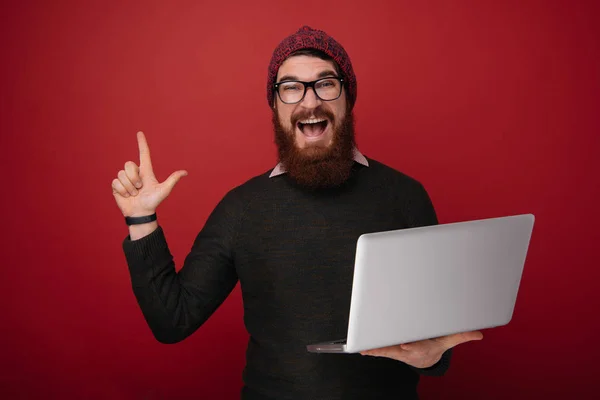 Retrato Hombre Barbudo Excitado Sosteniendo Computadora Portátil Apuntando Con Dedo — Foto de Stock
