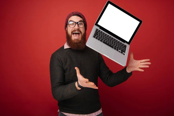 Bonitão Animado Barbudo Vestindo Óculos Segurando Laptop Elevando Tentando Pegá — Fotografia de Stock