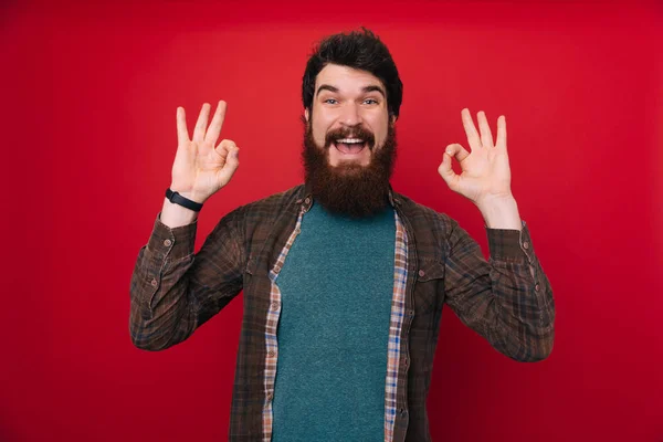 Portret Pozytywny Hipster Facet Pokazuje Znak Uśmiechający Się Brodaty Mężczyzna — Zdjęcie stockowe