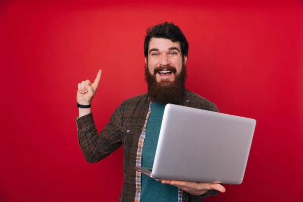 Junger Bärtiger Mann Über Roter Wand Mit Computer Laptop Überrascht — Stockfoto