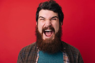 Sakallı acımasız adam çığlık ve kameraya bakıyor. Sakallı deli adam