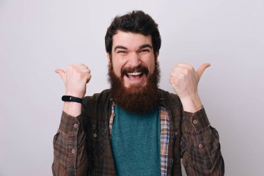 Bir handsoem mutlu komik sakallı adam Haritayı görme başparmak yukarıya ve iyi şans 