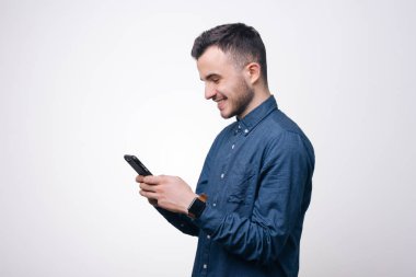 Smartphone Studio'yu kullanarak beyaz arka plan üzerinde mavi tişörtlü adam akıllı rahat ypung