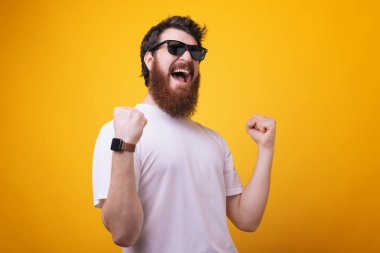 Güneş gözlüğü, giyen şanslı genç hipster sakallı adam bir şey kazandı gibi davranır