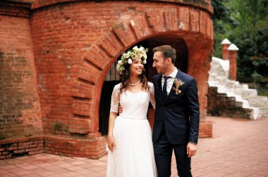 Damat ve gelin vurdu eski kırmızı tuğla yapı, açık duran portre.