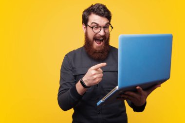 Gözlüklü, çığlık ve laptop işaret heyecanlı sakallı adam fotoğrafı
