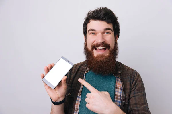 Tiro Tipo Hansome Aislado Sobre Fondo Gris Presentando Teléfono Inteligente — Foto de Stock