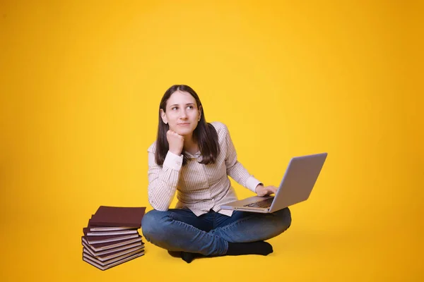 年轻的女学生坐在交叉的腿与笔记本电脑 年轻的学生生活 — 图库照片