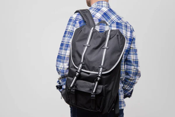 Backcpack とチェックの青いシャツでハンサムな男の背面図 — ストック写真