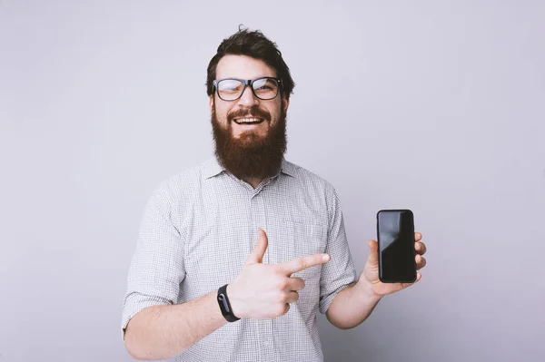 Gambar Pria Berjanggut Menunjuk Jari Pada Smartphone Mencari Dan Tersenyum — Stok Foto