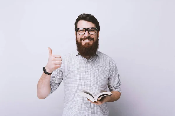穿着衬衫的聪明开朗的男人的肖像 拿着一本书 竖起大拇指 — 图库照片