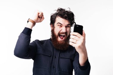 Handsomen sakallı genç adam onun wonn kutluyor ve beyaz arka plan üzerinde el hareketi