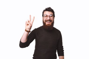 Barış, zafer işareti gösterilen ve kameraya gülümseyen bardaklarda çekici sakallı adam 