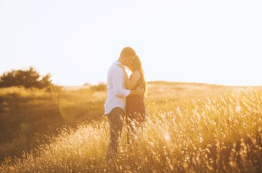 Bir güzel çift sarılma ve tepe üzerinde sunset bulvarında öpüşme