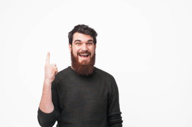 Beyaz arka plan üzerinde kopya alanı parmağı yukarıyı mutlu sakallı adam
