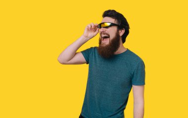 Sakallı adam bir yana sarı backgr gülümseyerek bakan genç heyecanlı