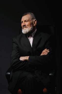 Bir şık yakışıklı olgun sakallı adam çapraz elleri olan bir tekli olarak portresi. Moda vurdu. Erkek giyim 