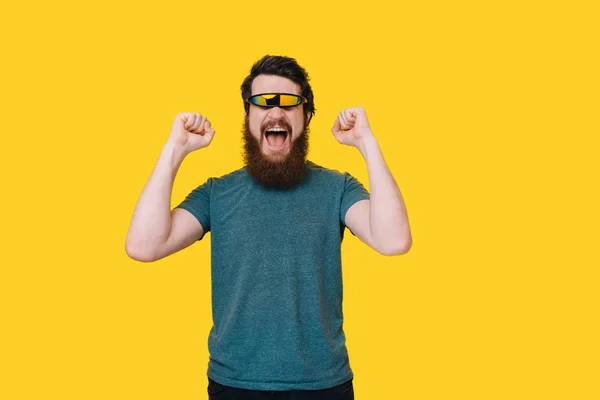 Barbudo hombre feliz con gafas futuristas haciendo gesto de victoria en —  Fotos de Stock