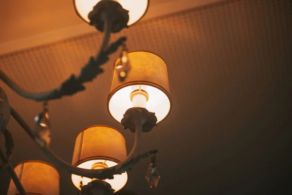 Upward view of a chandelier with yellow bulbs. Ceilling lamp. Wa