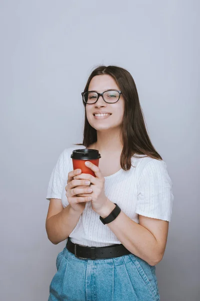Fröhliches Teenager-Mädchen mit Brille lächelt und hält ein c — Stockfoto