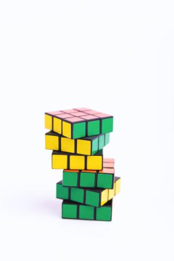 İki renkli Rubik küpü diğeri üzerinde, beyaz arka planda bir fotoğraf 