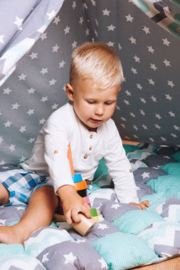 Onun küçük Wigwam içinde sarışın saç oynayan küçük bir çocuk