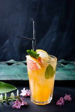 Koyu arka planda bir bardakta greyfurt ve nane dilim ile bir narenciye limonata fotoğrafı 